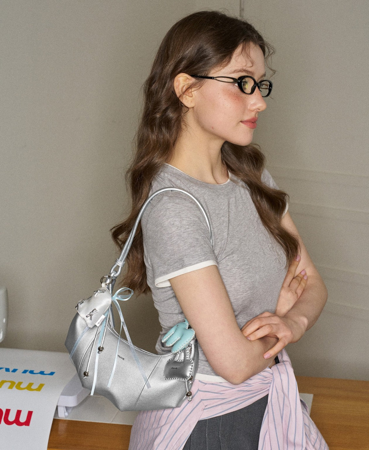 Model carrying the Jingle Mini Croissant Bag in Moon Rock Silver