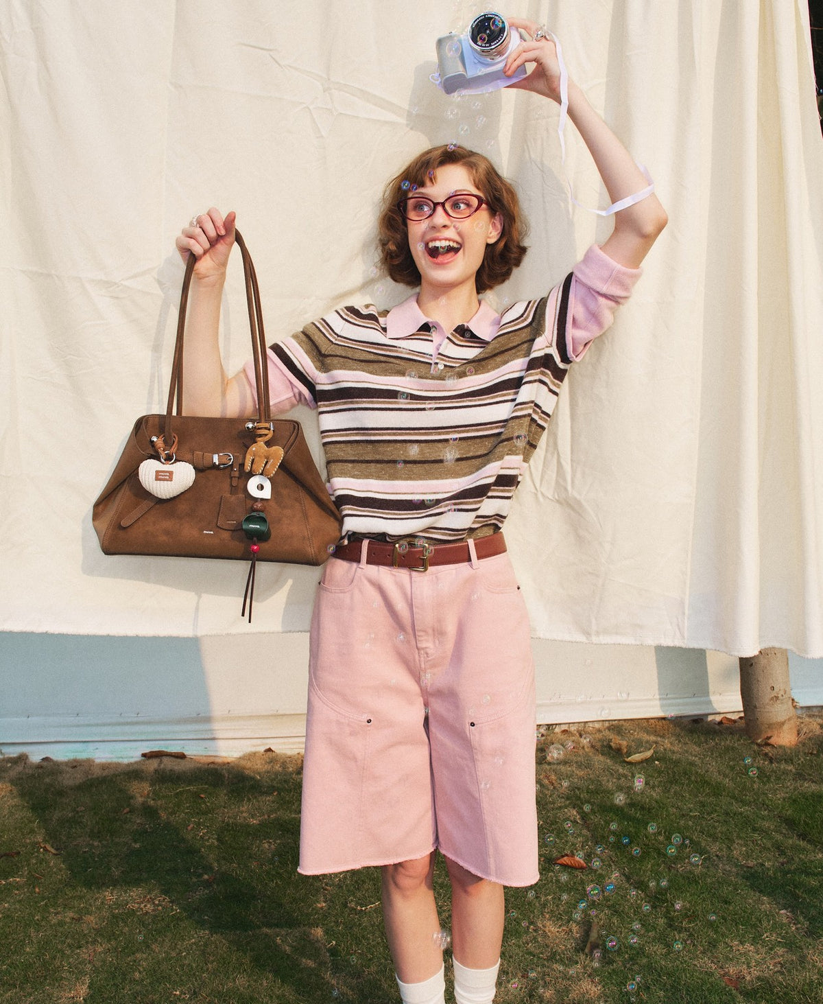 Model carrying the Tab Strap Fold-Over Shoulder Bag · Microsuede in Latte Brown