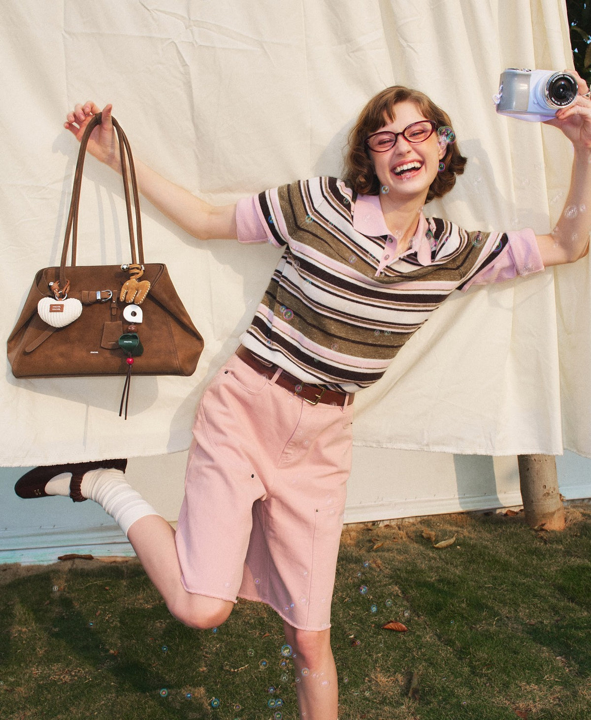 Model carrying the Tab Strap Fold-Over Shoulder Bag · Microsuede in Latte Brown