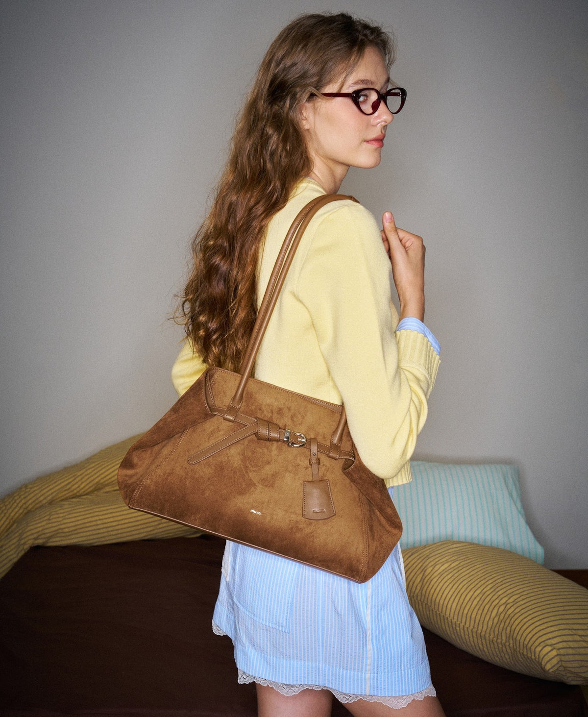 Model carrying the Tab Strap Fold-Over Shoulder Bag in Caramel Brown