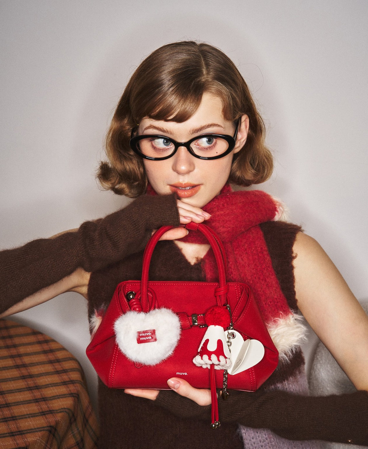 Model carrying the Tab Strap Fold-Over Handbag · Microsuede in Red