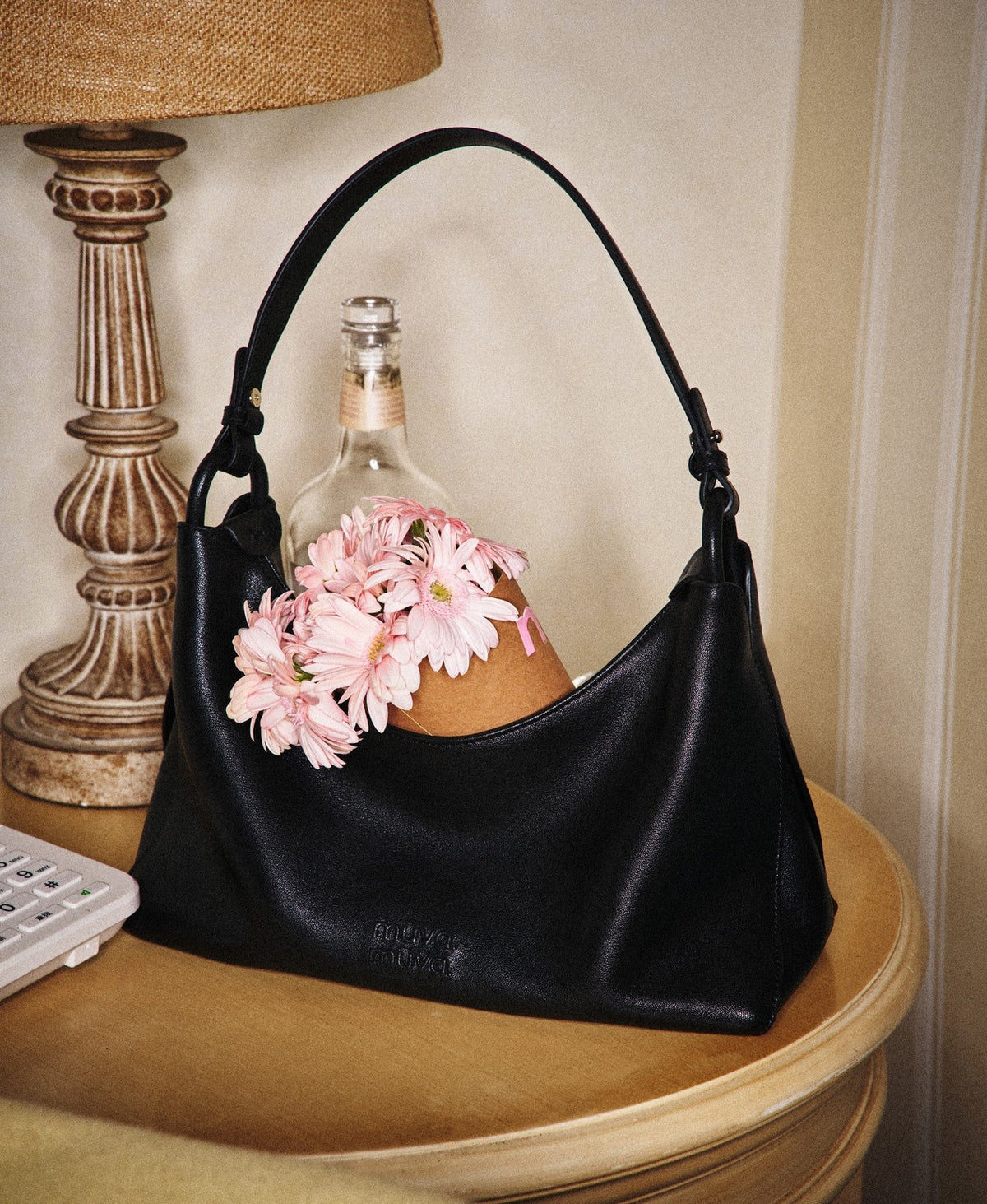 Model carrying the Bakery Croissant Shoulder Bag in Black