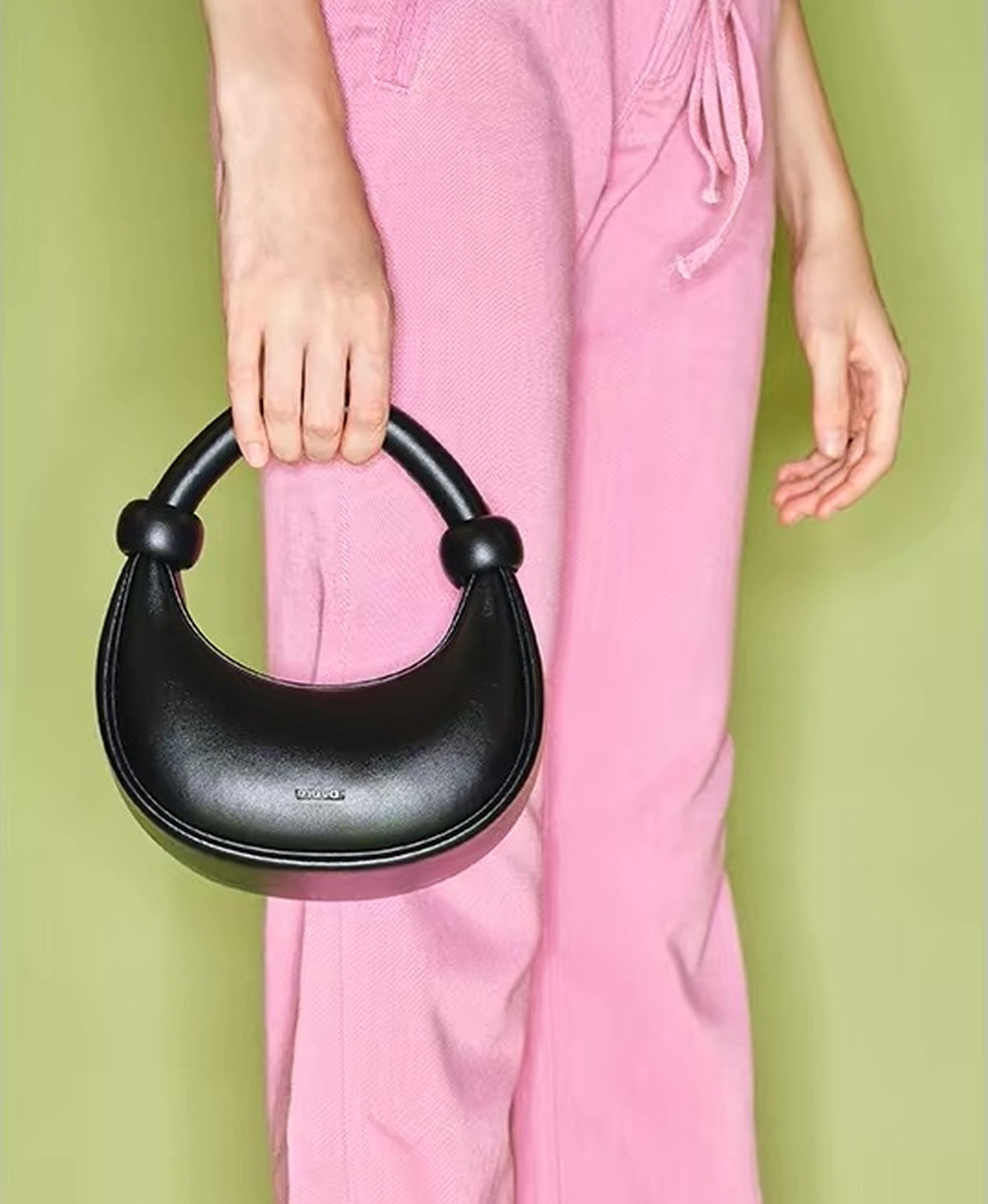 Model carrying the ZhuZhu Bag · Medium in Black by its handle