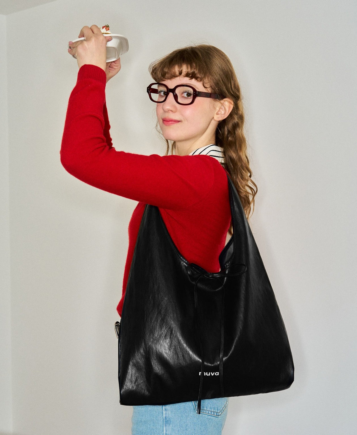 Model carrying the Roly-Poly Pleat Tote in Premium Black