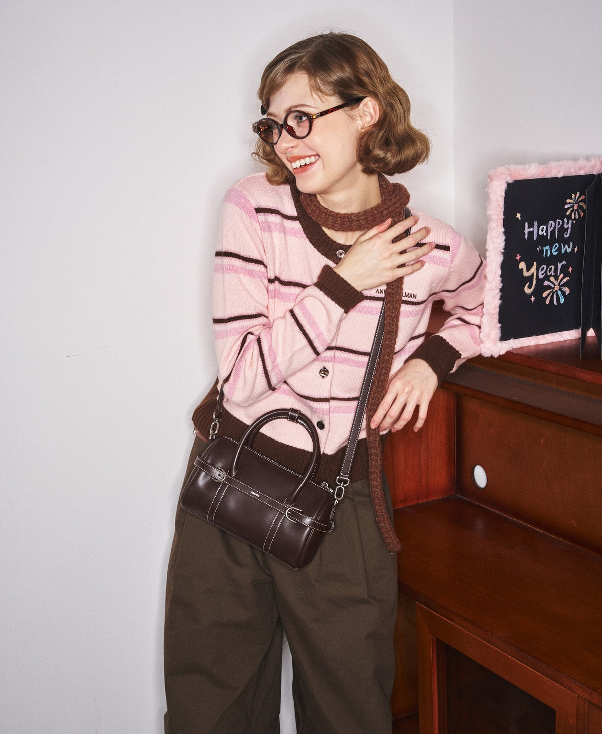 Model carrying the Hopscotch Tales Pillow Bag in Chocolate Brown
